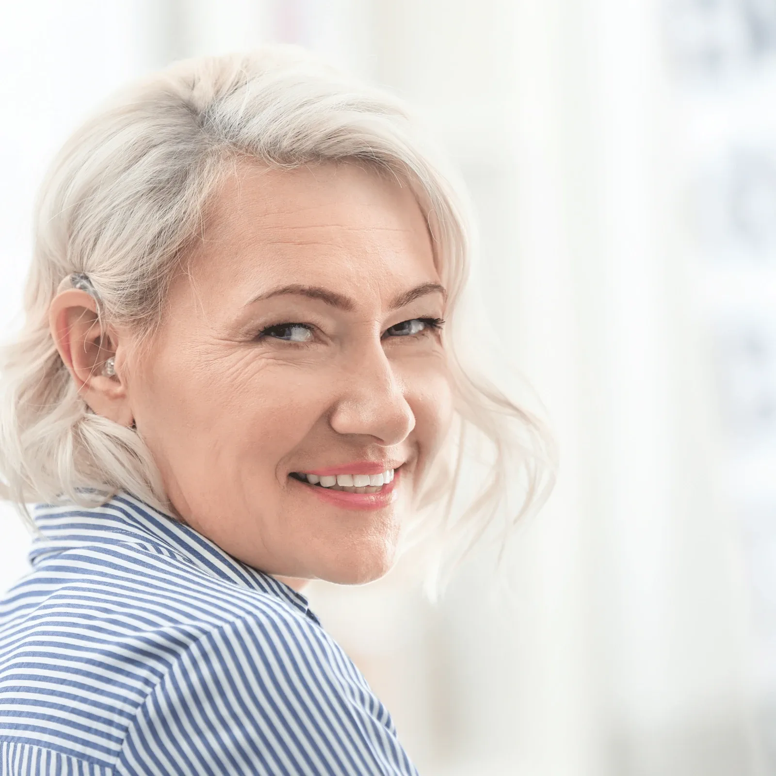 Frau mit Hörgerät lächelt